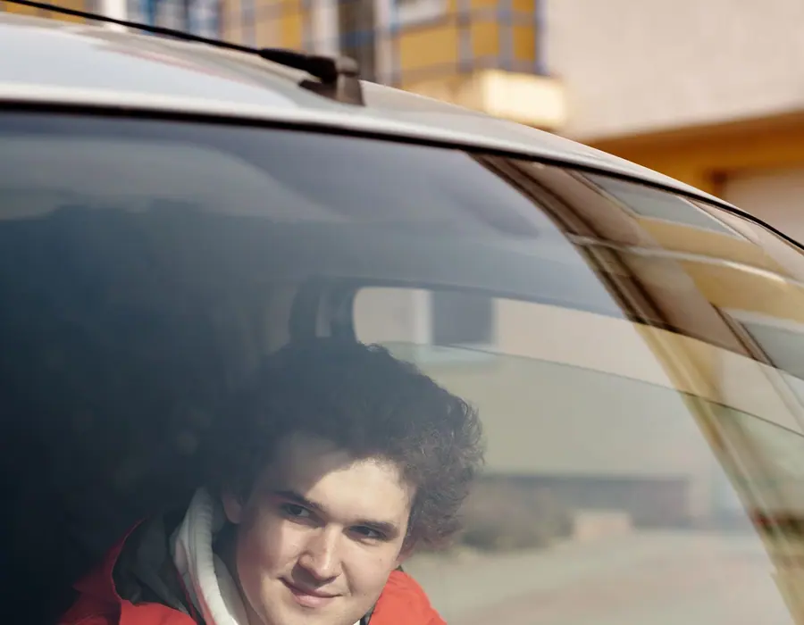 Condutor sorrindo no banco do motorista com o carro parado